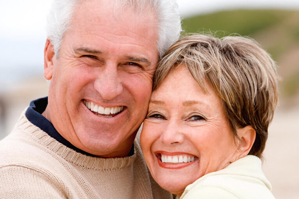 photo of couple with dental implants smiling